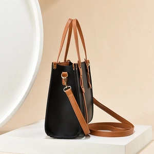 Contrast color large tote bag with textured leather and gold hardware in a side view