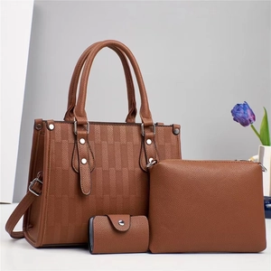 Dettaglio del set borsa tote marrone trama litchi con pochette e porta carte abbinati