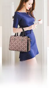 Vue détaillée d'un sac à main vintage à imprimé trèfle marron avec poignées noires et métal