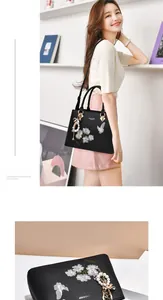 Détail d'un sac à main en cuir noir avec broderie florale et breloque papillon en perles