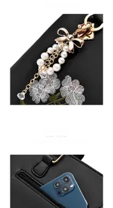 Détail de broderie florale, breloque perle et poche zippée sur sac en cuir noir