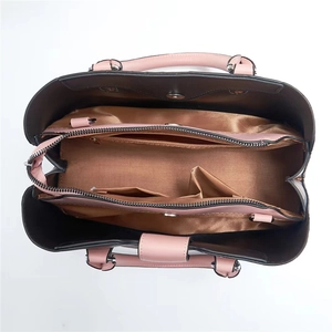 Interior detail of large tote bag showing bronze satin lining and multiple compartments