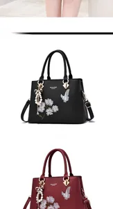 Détail du sac cabas brodé de fleurs avec pendentif nœud perlé en noir et bordeaux