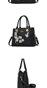 Détail du sac à main en cuir PU noir avec broderie florale et breloque perle