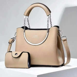 Détail du sac seau beige à grain de litchi avec chaîne et poignée métallique