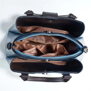 Top view of blue tote bag interior with three main compartments and magnetic snaps