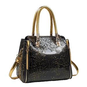 Vintage floral embossed tote bag in glossy black leather with gold metal handles