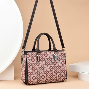 Elegante borsa beige con stampa floreale rossa e manici in pelle marrone