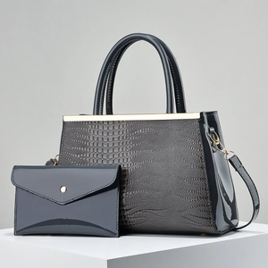 Detail of dark blue crocodile texture handbag and glossy clutch with gold metal accents