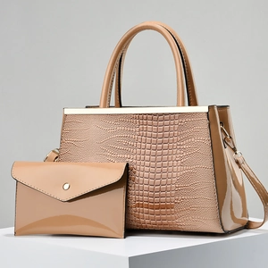 Detailed close-up of khaki faux crocodile skin texture and gold metal accents on tote bag