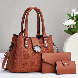 Detailed view of caramel brown three-piece bag set with woven texture and metal closure