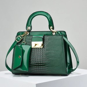 Detail of dark green lizard pattern tote with glossy patent leather finish and gold buckle