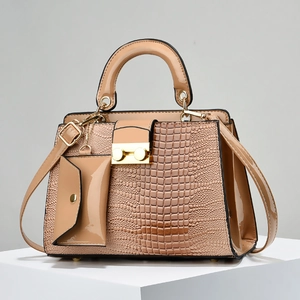 Detailed macro view of light brown lizard pattern handbag with golden metal buckle and strap