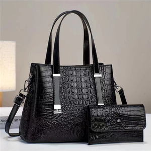 Detail der schwarzen Kroko-Handtasche mit passender Brieftasche und silbernen Beschlägen