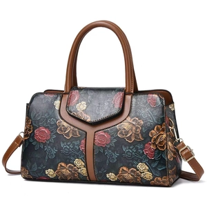 Detail of vintage tote bag featuring embossed rose floral patterns and brown leather straps