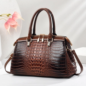Dark brown crocodile embossed leather handbag with gold hardware and shoulder strap