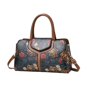 Vintage floral embossed pillow bag with brown leather handles and gold metal hardware