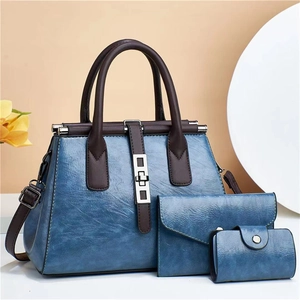 Close-up of three-piece vintage blue and brown leather handbags with silver hardware