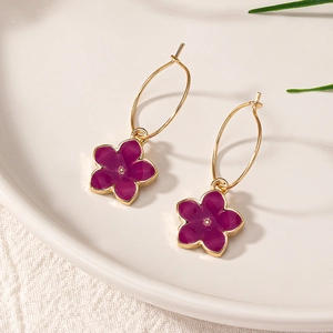 Boucles d'oreilles fleurs en émail violet avec créoles dorées sur plateau en céramique