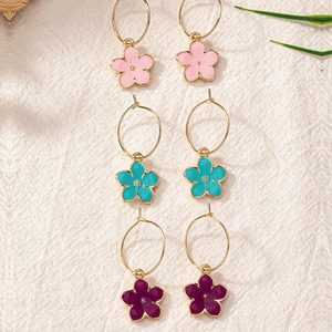 Ensemble de trois paires de boucles d'oreilles fleurs en émail coloré avec bords dorés