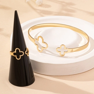 Ensemble bijoux trèfle à quatre feuilles doré avec bracelet et bague sur socle pierre