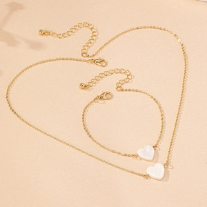Elegant gold jewelry set with heart-shaped shell pendants including necklace and bracelet