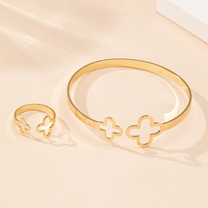 Détail du set bracelet et bague trèfle doré avec des ombres de découpe élégantes