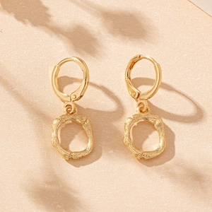 Elegant gold bamboo texture hoop earrings with minimalist huggie design and natural aesthetic