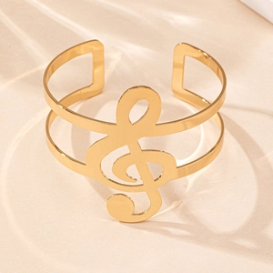 Vue détaillée du bracelet jonc ouvert doré avec motif clé de sol pour mélomanes