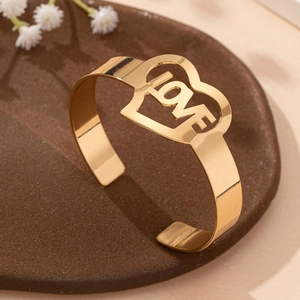 Elegante bracciale aperto in oro con cuore traforato e scritta LOVE in finitura lucida
