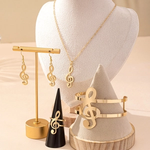 Elegant gold music note jewelry set featuring necklace earrings ring and bracelet on stands
