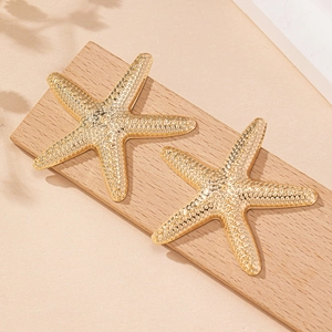 Fashionable gold starfish stud earrings with realistic textured surface for beach vacation
