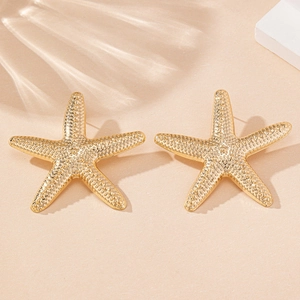 Detailed close-up of gold starfish stud earrings with textured surface and beachy vibe