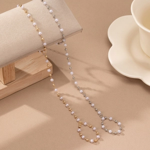 Elegant pearl and gold bead chain accessory for glasses or mask shown on beige stand