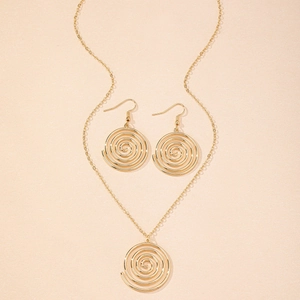 Detail eines eleganten goldenen Schmucksets mit Spiralanhänger-Halskette und passenden Ohrringen