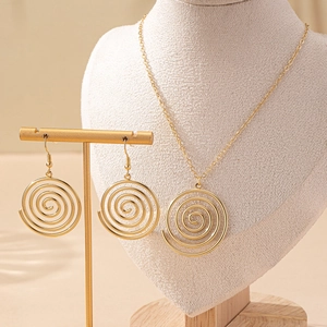 Elegantes Set aus goldener Wirbel-Halskette und passenden Spiralohrringen auf Schmuckständer