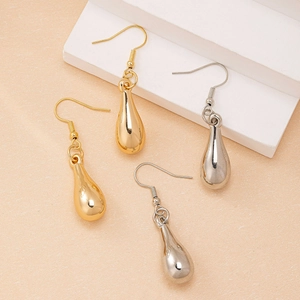 Macro shot of gold and silver teardrop earrings with mirror finish on a display stand