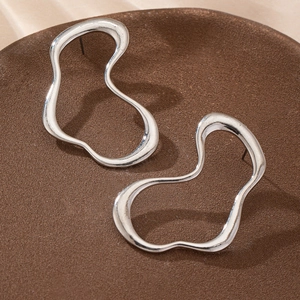 Orecchini a cuore in argento minimalisti con finitura lucida su un espositore testurizzato