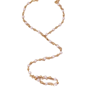 Elegant gold bead and pearl body chain harness for women on plain white background