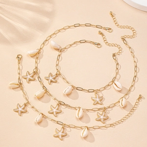 Detailed view of three gold-tone chains with natural seashells and starfish pendants