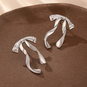 Silver bow ribbon stud earrings with glossy metallic finish in a minimalist design