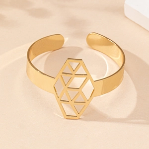 Macro shot of gold hollow geometric hexagonal pattern on an elegant open cuff bracelet