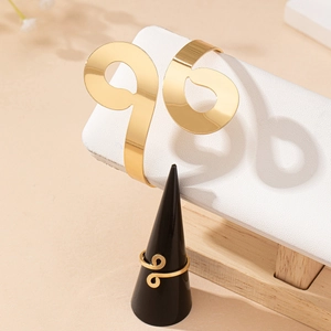 Golden jewelry set featuring geometric figure 8 bracelet and spiral wrap ring design