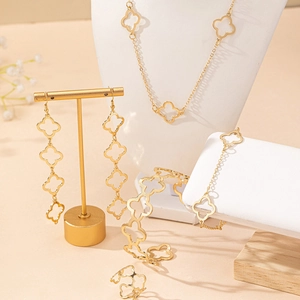 Elegant gold hollow four-leaf clover jewelry set with necklace, bracelet, ring, and earrings