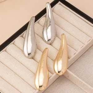 Elegant gold and silver teardrop earrings with hammered texture on a jewelry display