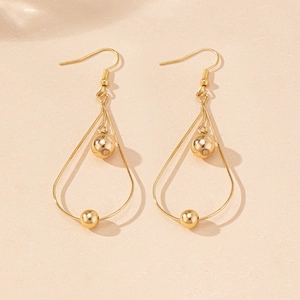 Detailed view of elegant gold-toned hollow teardrop earrings with central metal bead accents