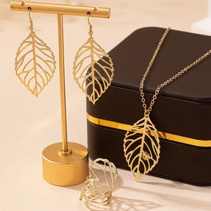 Elegant gold hollow leaf jewelry set with necklace earrings and ring on display