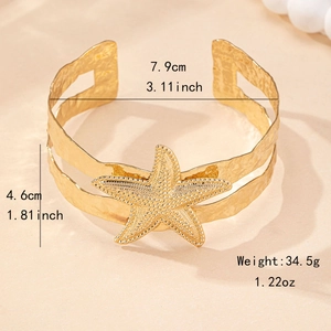 Golden starfish arm cuff bracelet with hollow textured metal for summer beach vacation