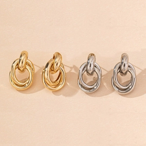 Detail of interlocking triple-ring earrings in polished gold and silver finish