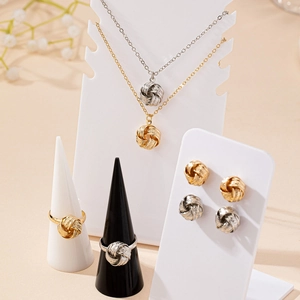 Elegant twisted love knot jewelry set featuring necklace, ring, and studs in gold and silver